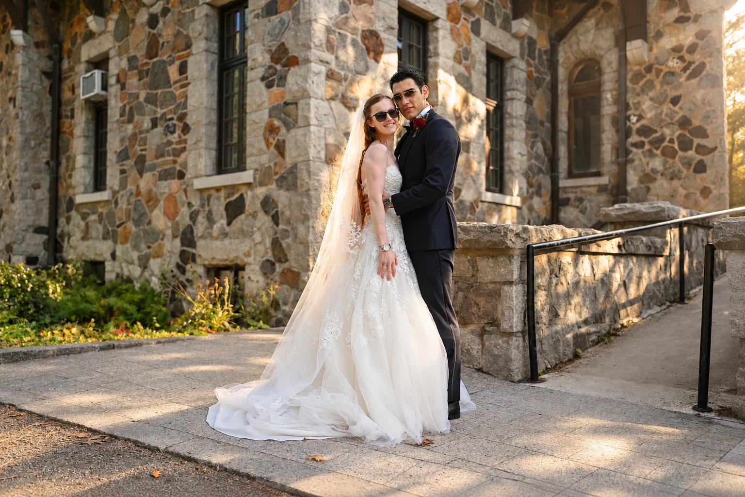 Jenna and Pouya by the stone wall at golden hour