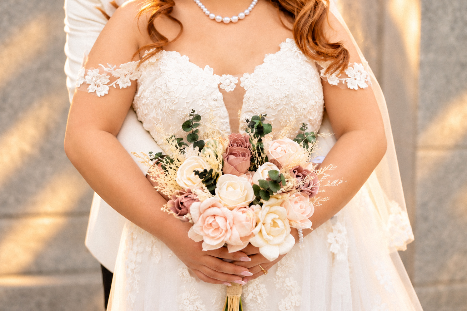 Mae holding her bouquet during an embrace