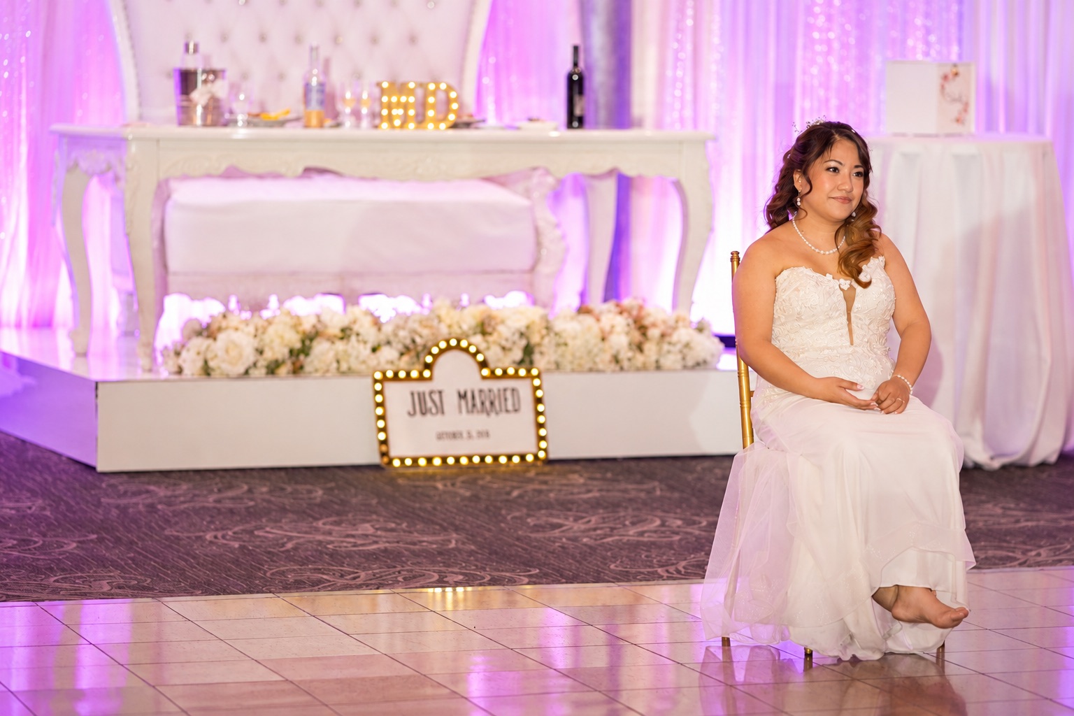 Mae seated beside the just married sign
