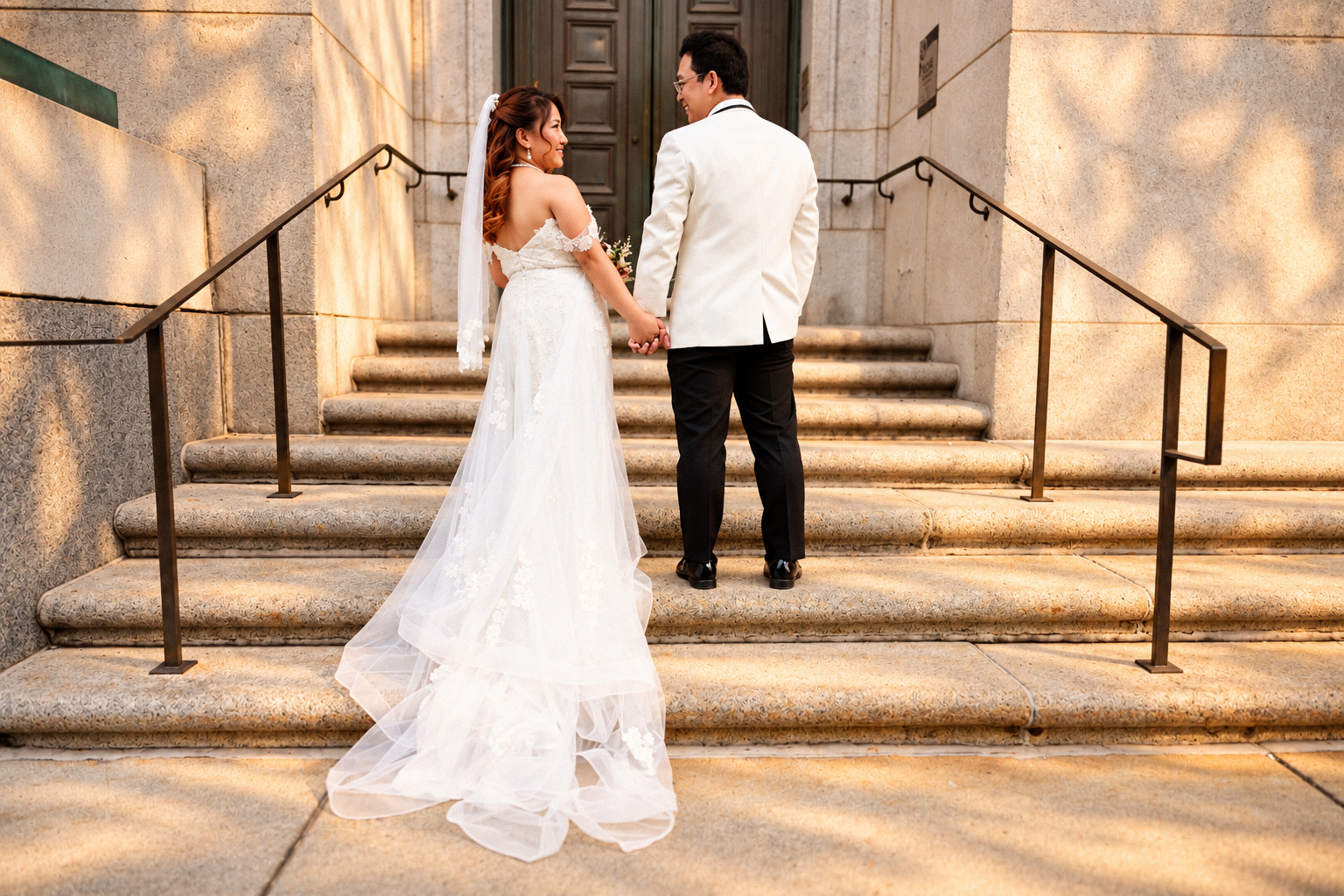 Mae and Daryl holding hands on the stone stairway