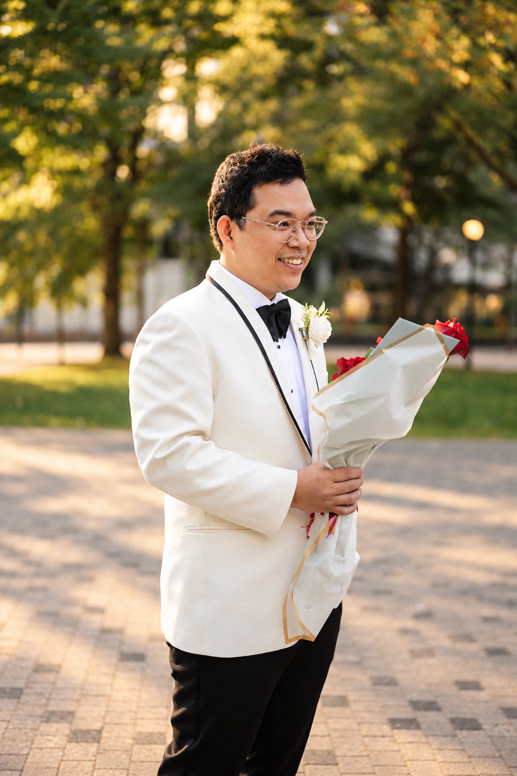 Daryl in his white tuxedo holding red roses