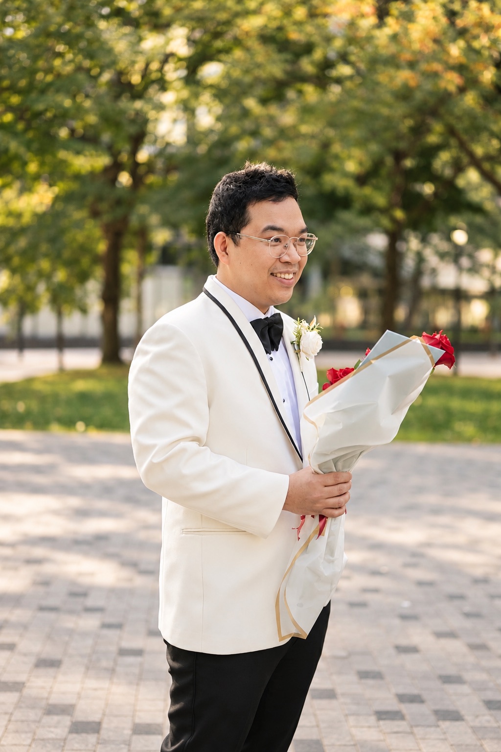 Daryl holding a bouquet of red roses in the park
